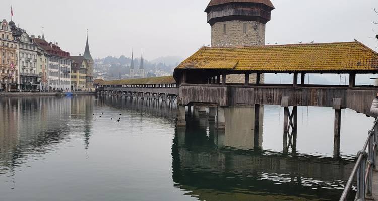Historic wooden covered bridge over a calm river.
