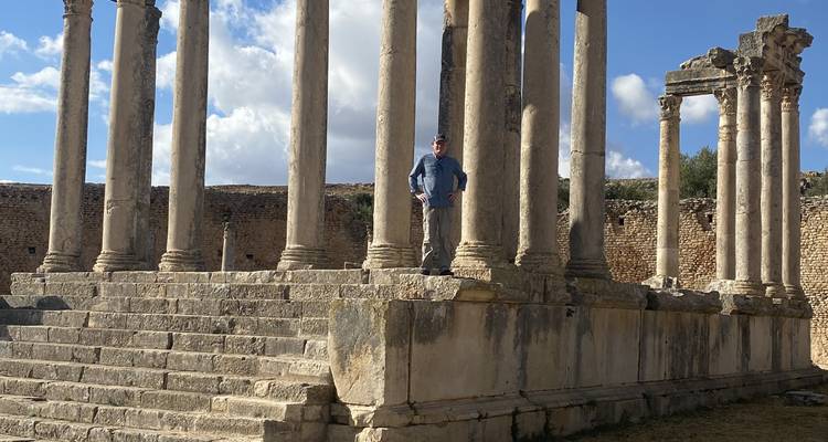 Ruins of an ancient structure with a person standing on the steps.