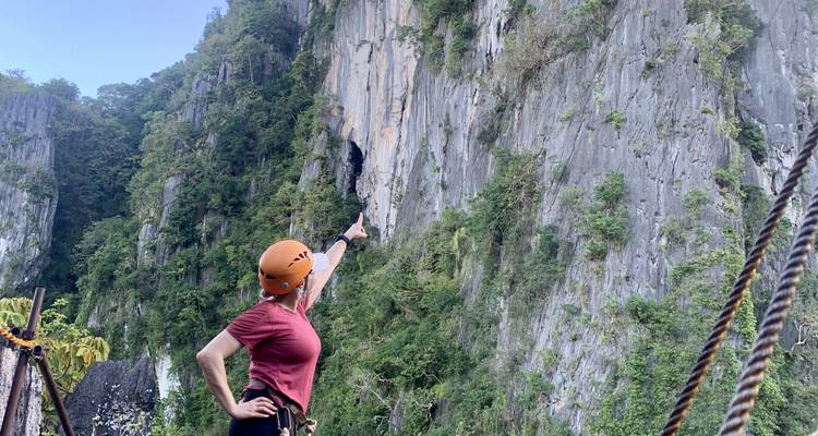 Personne pointant vers le haut sur une falaise escarpée.