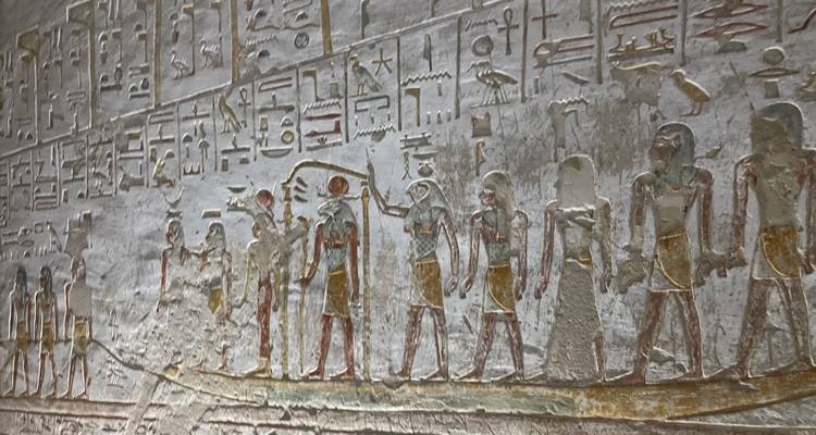 Mur de l'Égypte ancienne avec des sculptures détaillées et des hiéroglyphes.