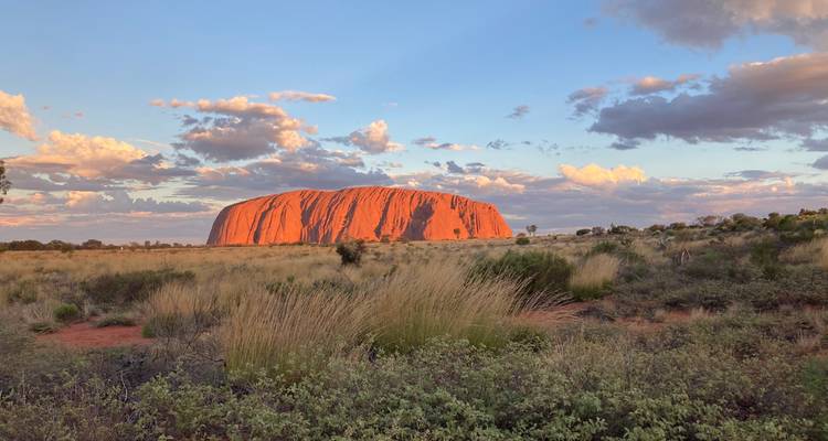 Uluru during sunset with clouds.
