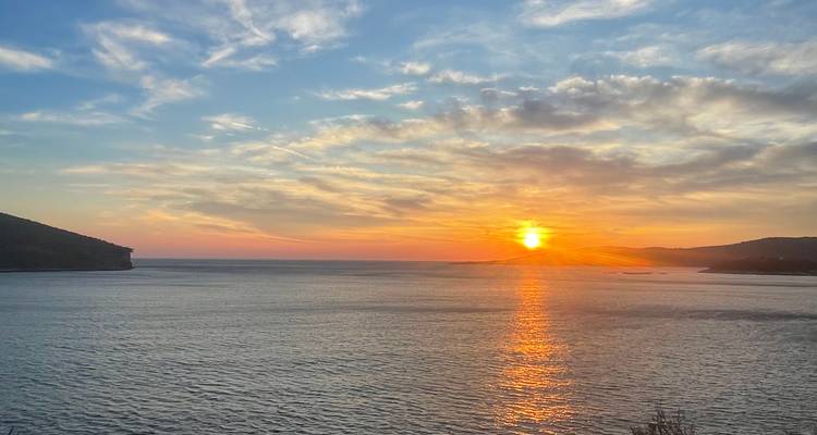 Sunset over the sea with a dramatic sky view.