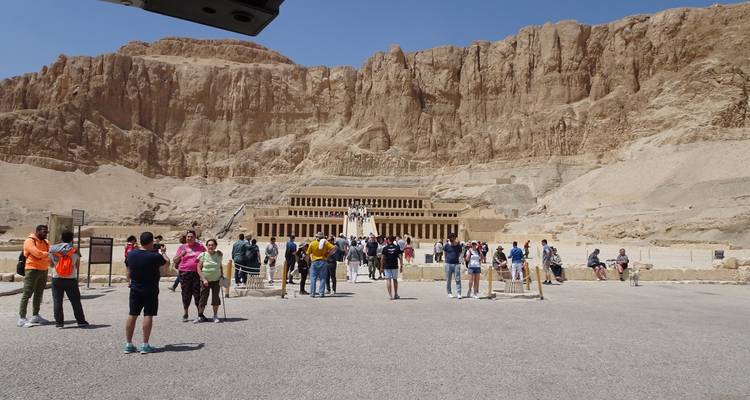 Toeristen die de Tempel van Hatshepsut bezoeken met zandstenen kliffen.