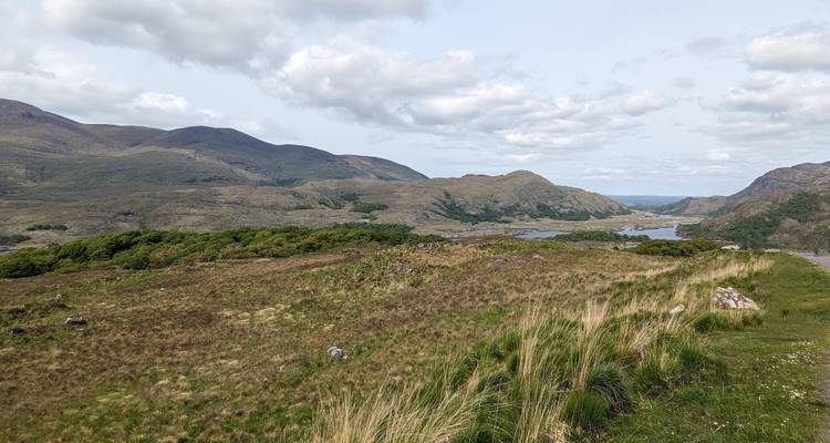Hügelige Landschaft mit Blick auf Seen und Berge.
