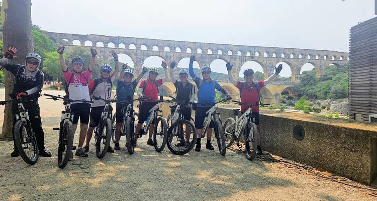 Cyclists posing in front of the Pont du Gard aqueduct.