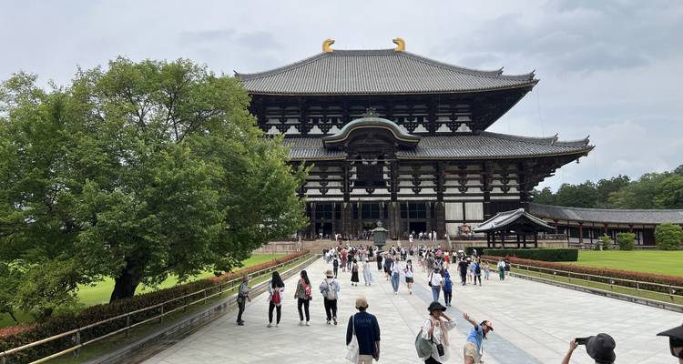 Grand temple traditionnel avec des personnes sur la passerelle.