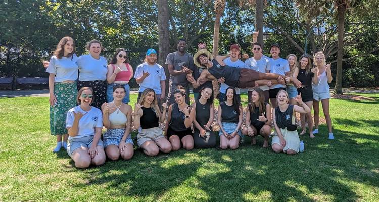 Photo de groupe dans un parc avec des arbres.