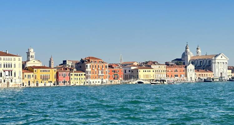 Colorful waterfront buildings with a church in Venice.