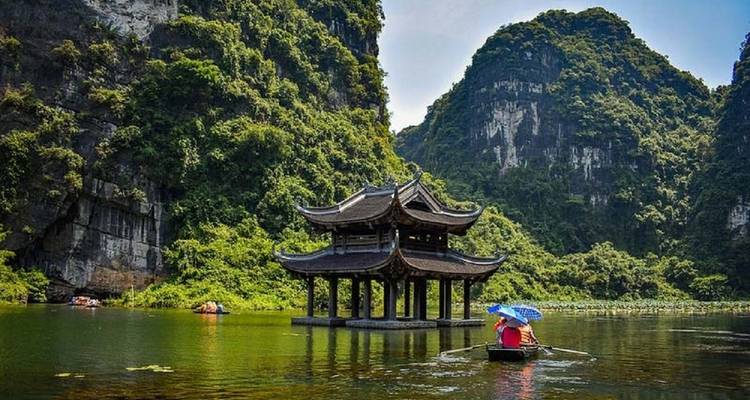 Boat ride around a historical temple and towering cliffs.