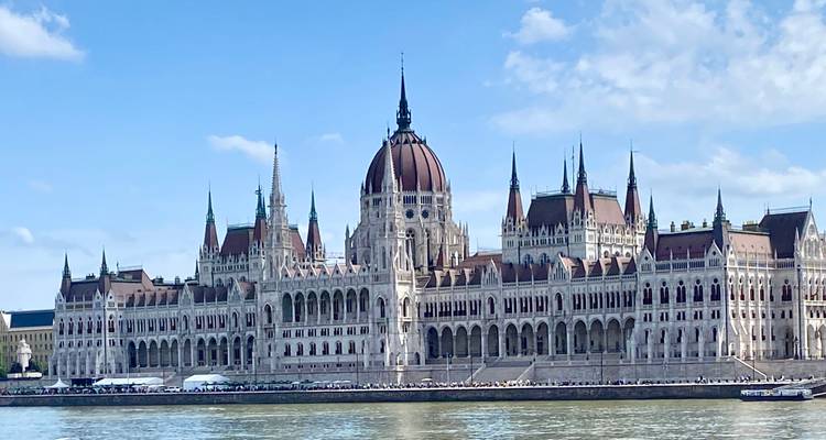 Elegant building with spires by a river.