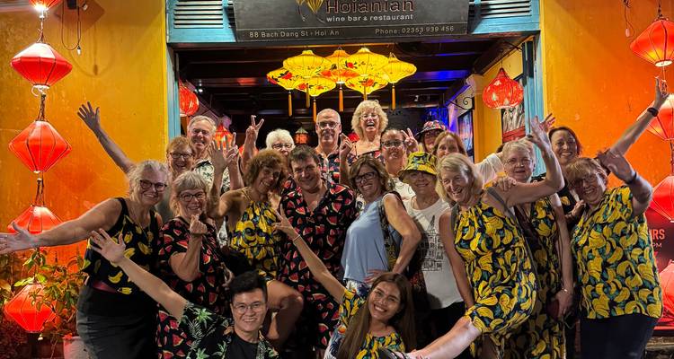 Large group photo in front of a lantern-covered entrance.