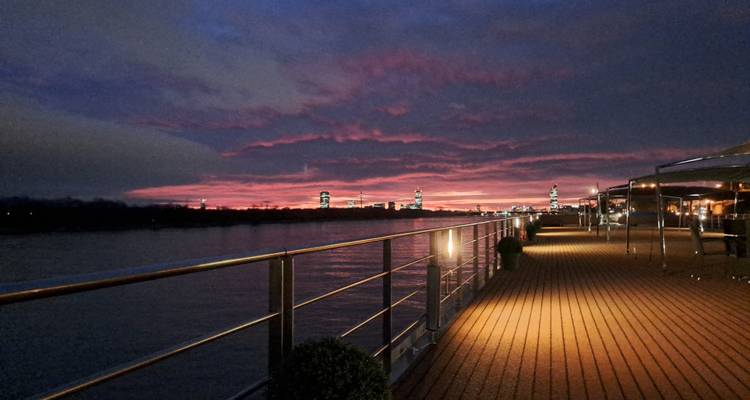 Sunset view from a deck overlooking a river.
