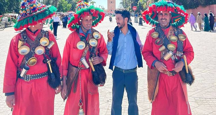 Four men in traditional attire engaged in a conversation.