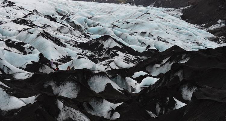 Gruppenwanderung auf einem Gletscher mit dunklem und hellem Kontrast.