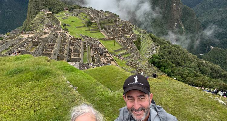 Couple smiling with Machu Picchu ruins in the background.