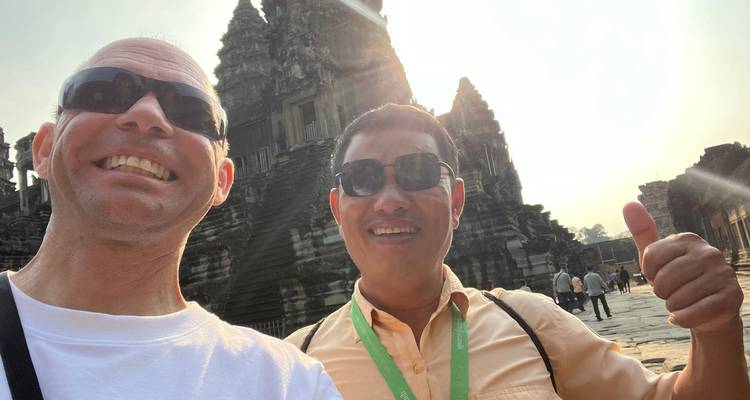 Two people smiling in front of an ancient temple.