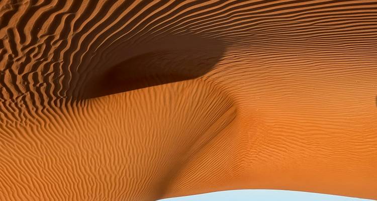 Golden sand dunes under a clear blue sky.