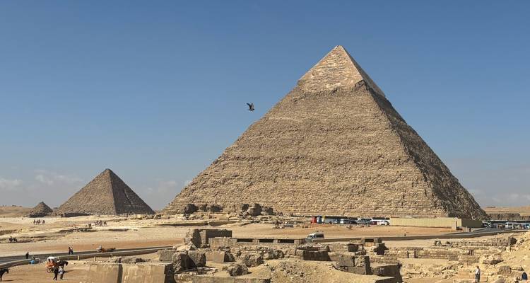 Piramides van Giza met een heldere blauwe lucht en mensen op de voorgrond.