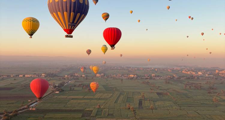 Heteluchtballonnen die zweven boven een schilderachtig landschap bij zonsopgang.
