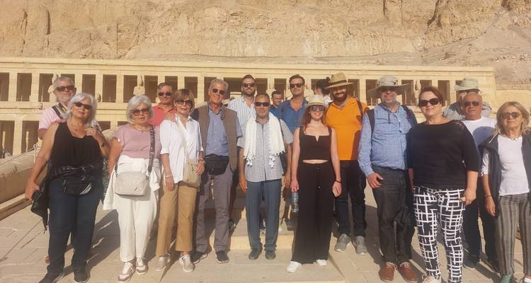 Group of tourists posing in front of an ancient temple.