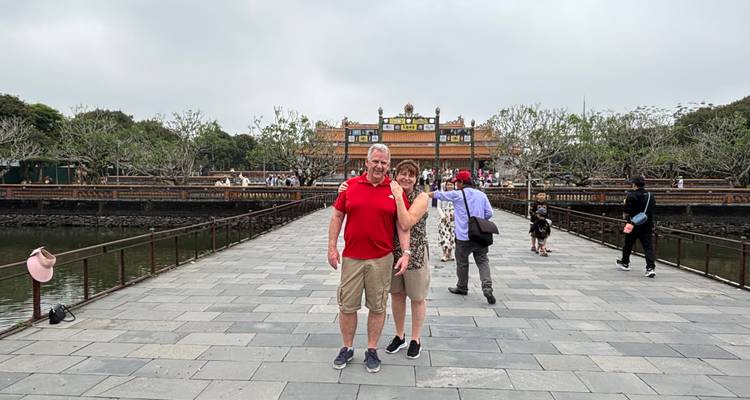Couple on a bridge in front of a historical building.