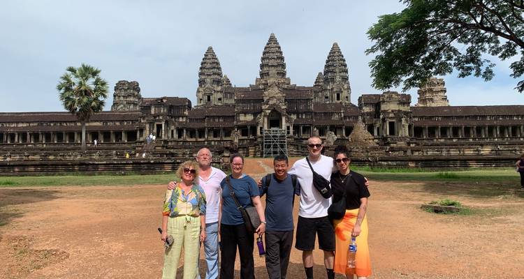 Grupo de turistas posando con Angkor Wat de fondo.