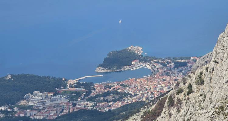 Aerial view of a coastal city with a mountain backdrop.