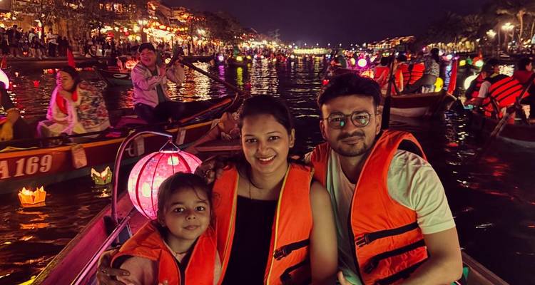 Family on a boat during a night lantern festival.