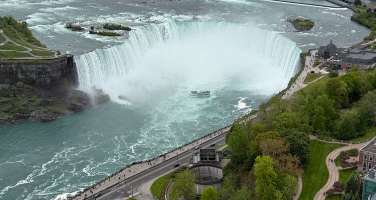 Aerial view of Niagara Falls with surrounding greenery.