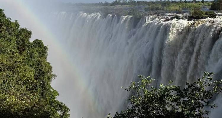 Victoria Falls with a rainbow over the waterfall.