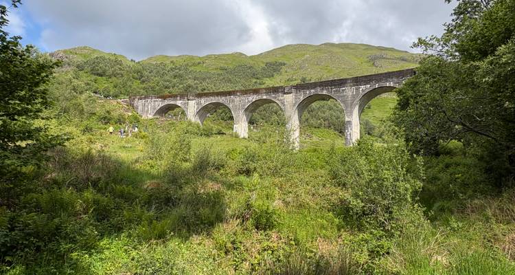 Un paysage verdoyant pittoresque avec un grand viaduc.