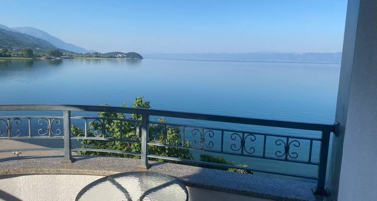 Vue sur le lac depuis un balcon avec des montagnes environnantes.