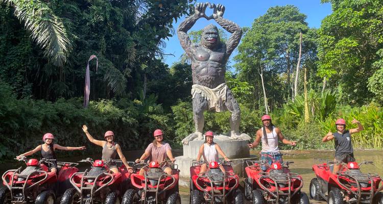 Groupe de personnes sur des VTT devant une statue géante.