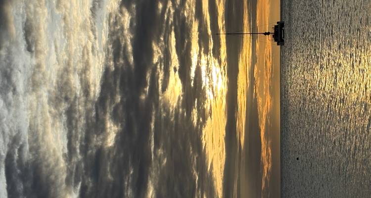 Un velero durante el atardecer en una masa de agua.