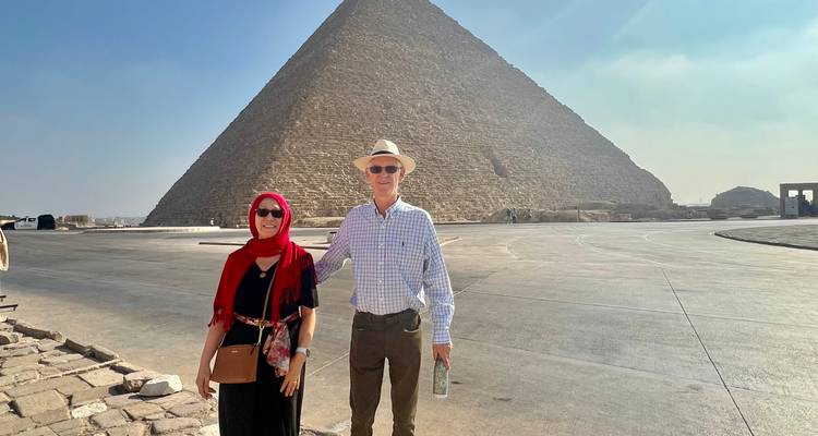 Couple posing in front of a pyramid.