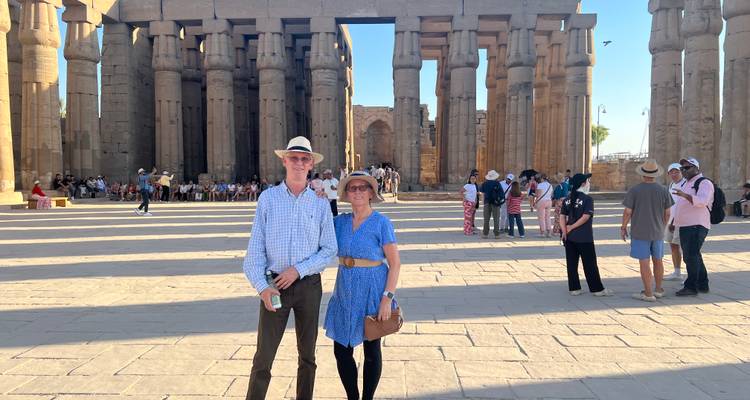 Couple posing in front of ancient Egyptian columns.