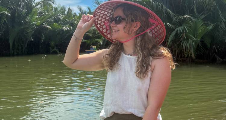 Woman in a conical hat enjoying a boat ride.