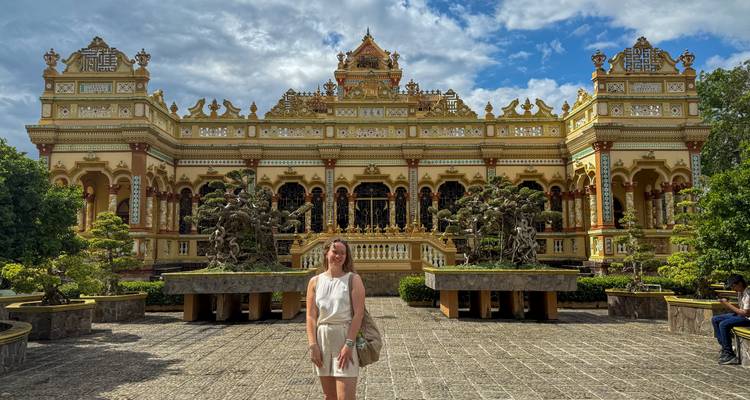 Personne à l'entrée d'un temple vietnamien posant pour une photo.