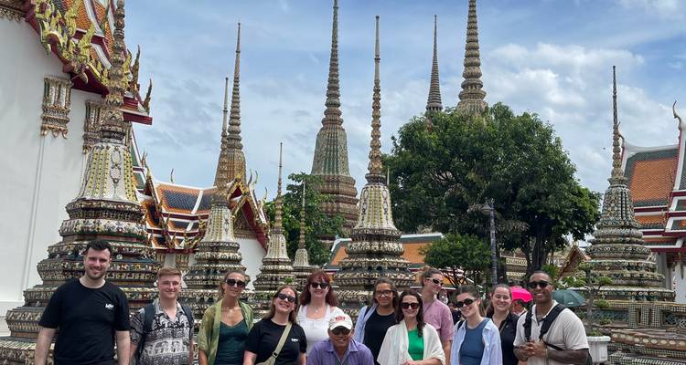 Groupe de personnes posant devant des stupas décoratifs dans un temple.