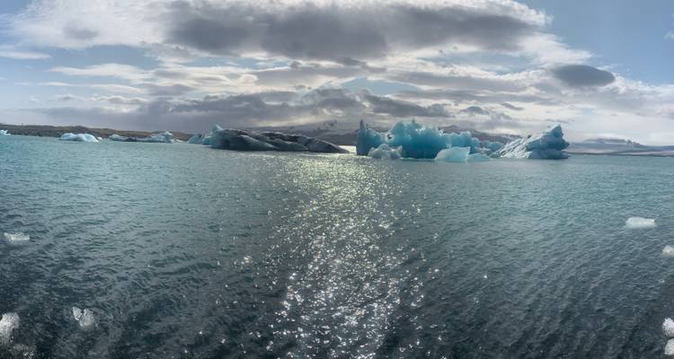 Large icebergs floating on a serene lake.