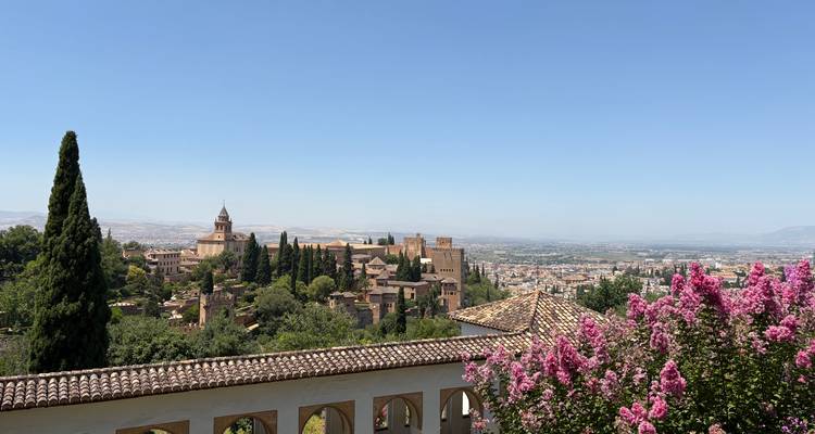 Une vue sur un jardin avec des bâtiments historiques et un ciel dégagé.