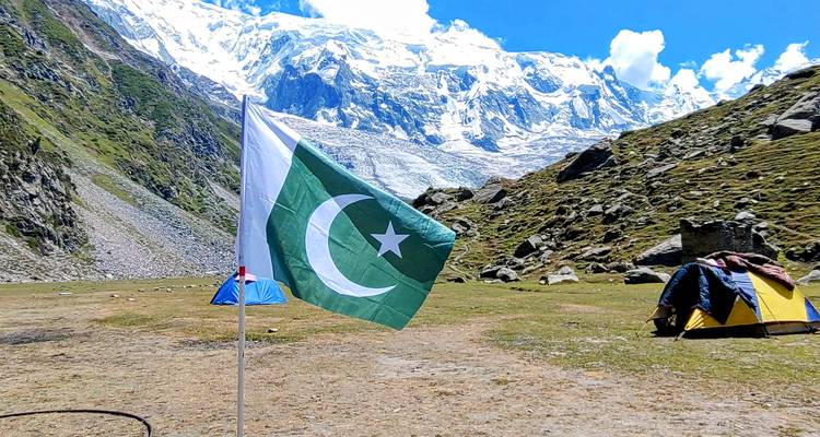 Drapeau du Pakistan dans un paysage montagneux avec des tentes