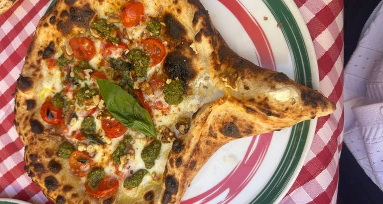 Pizza napolitaine avec garnitures fraîches et basilic.