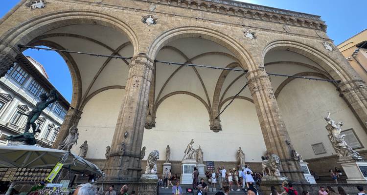 Des gens observant des statues sous des arches à Florence.