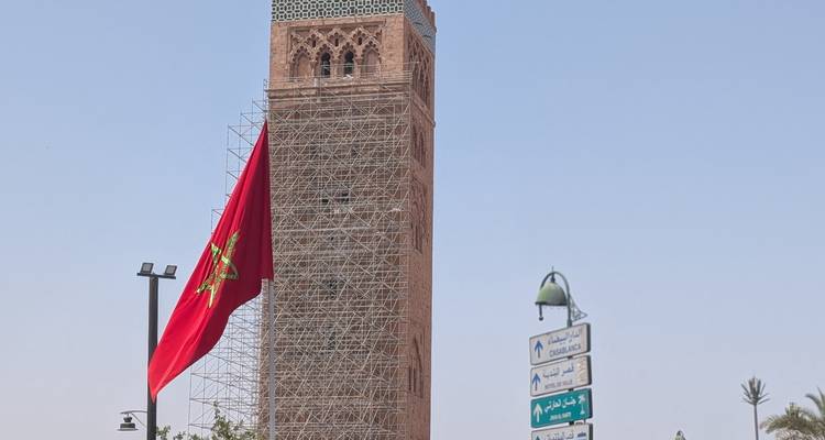 Minaret avec échafaudage et drapeau marocain.