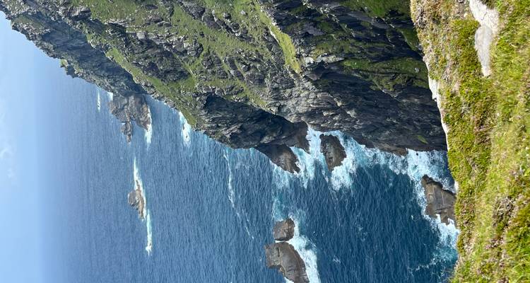 Falaises escarpées au bord de l'océan avec des vagues qui se brisent.