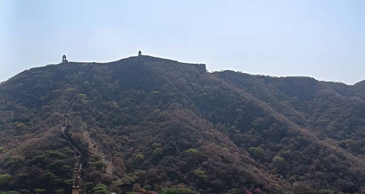 Gran muralla que se extiende sobre colinas boscosas, con torres de vigilancia.