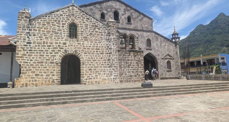 Stone church with a mountain backdrop and sunny weather