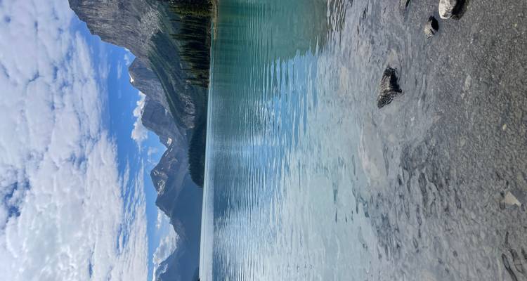 Un lac serein aux eaux turquoise claires entouré de hautes montagnes.