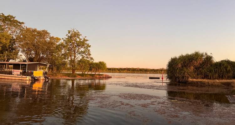 Une rivière avec un bateau près du rivage.